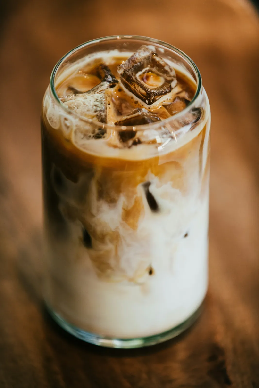 Iced latte with milk swirled through espresso in a glass